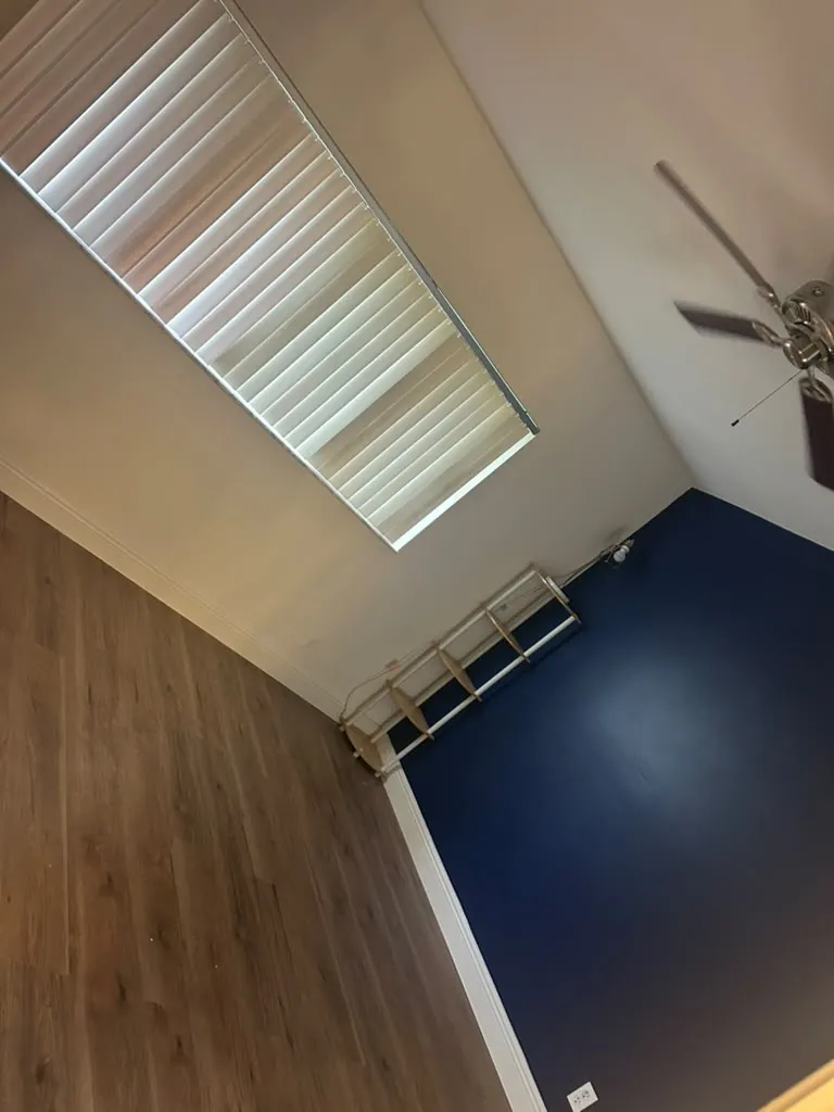 Navy bedroom wall and wood floor in the remodel.